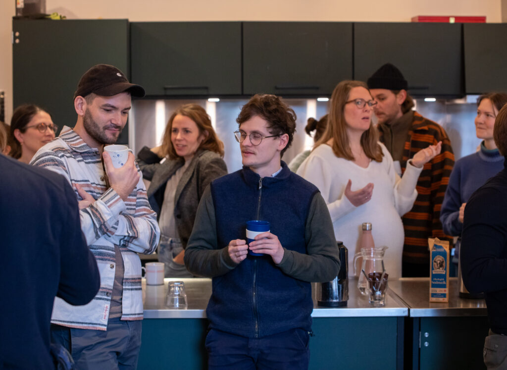 Unge mennesker drikker kaffe og taler sammen