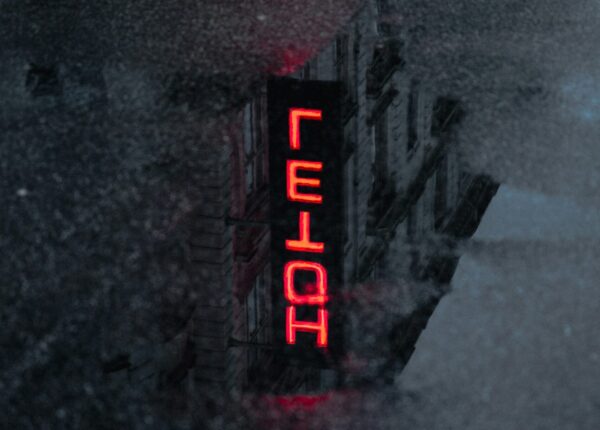Ordet hotel i neonlys på sort baggrund